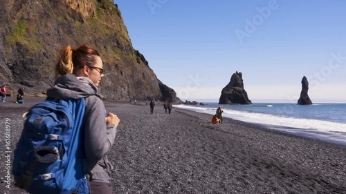 Woman exploring beautiful Reynisfjara beach near Vik, Icealnd photo