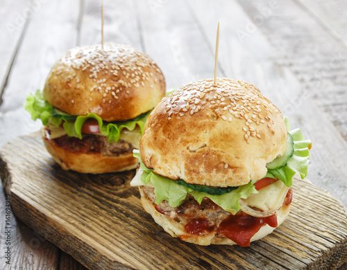 Homemade burgers on wooden background