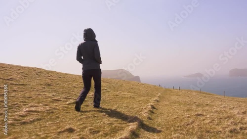 Tourist walking on Westman islands, Iceland photo