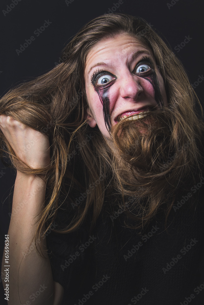 Crazy deranged woman pulling her hair out, scary and insane, halloween concept, possessed by evil spirits Crazy deranged woman pulling her hair out, scary and insane, halloween concept, possessed by evil spirits