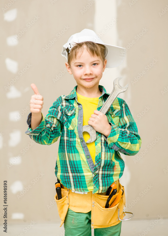 Happy boy with toolbelt and wrench showing thumbs up Happy boy with toolbelt and wrench showing thumbs up