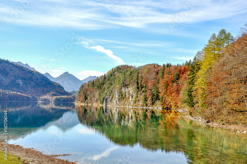 Lake with clear water, colorful trees and mountains with blue sky, near Neuschwanstein castle, Bavaria, Germany