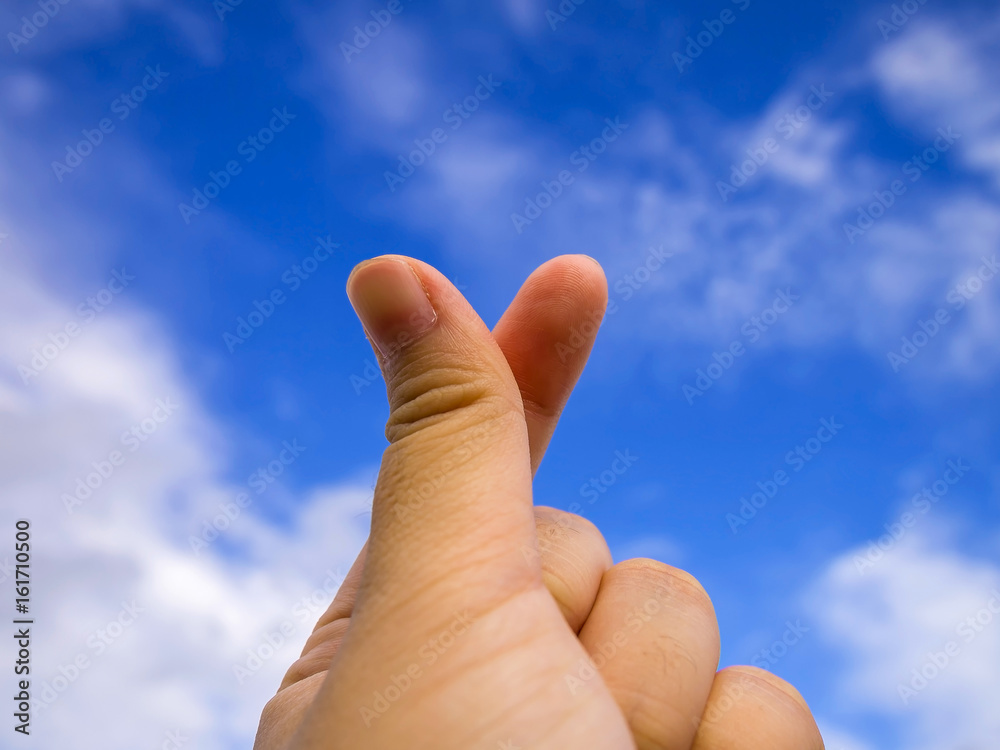 Close up action of young woman hand in mini heart by forefinger and thumb, Mini heart with blue sky, love symbolic of Korea. Close up action of young woman hand in mini heart by forefinger and thumb, Mini heart with blue sky, love symbolic of Korea.