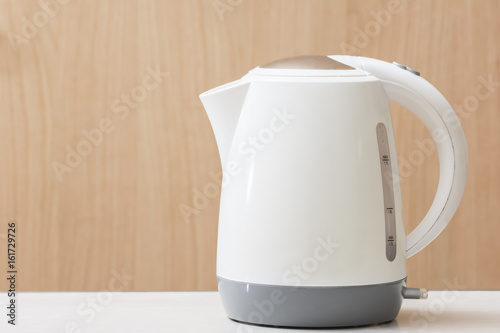 White Electric kettle quick boil on table and wooden background.
