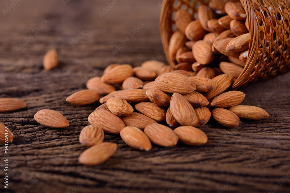 almond seed in basket and on wooden table almond seed in basket and on wooden table