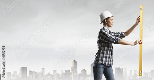 Builder woman taking measures . Mixed media