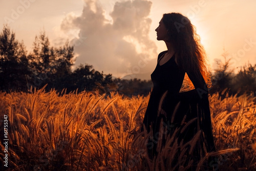 beautiful woman silhouette on sunset photo