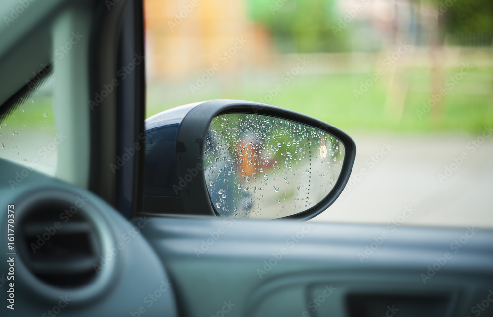 closeup of car mirror and rain drops