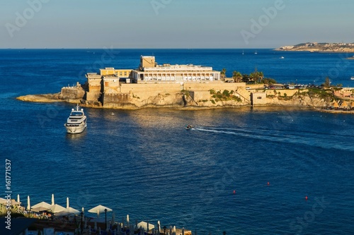 Sea, casino building on rock,yacht. St. George ´s bay, Malta.