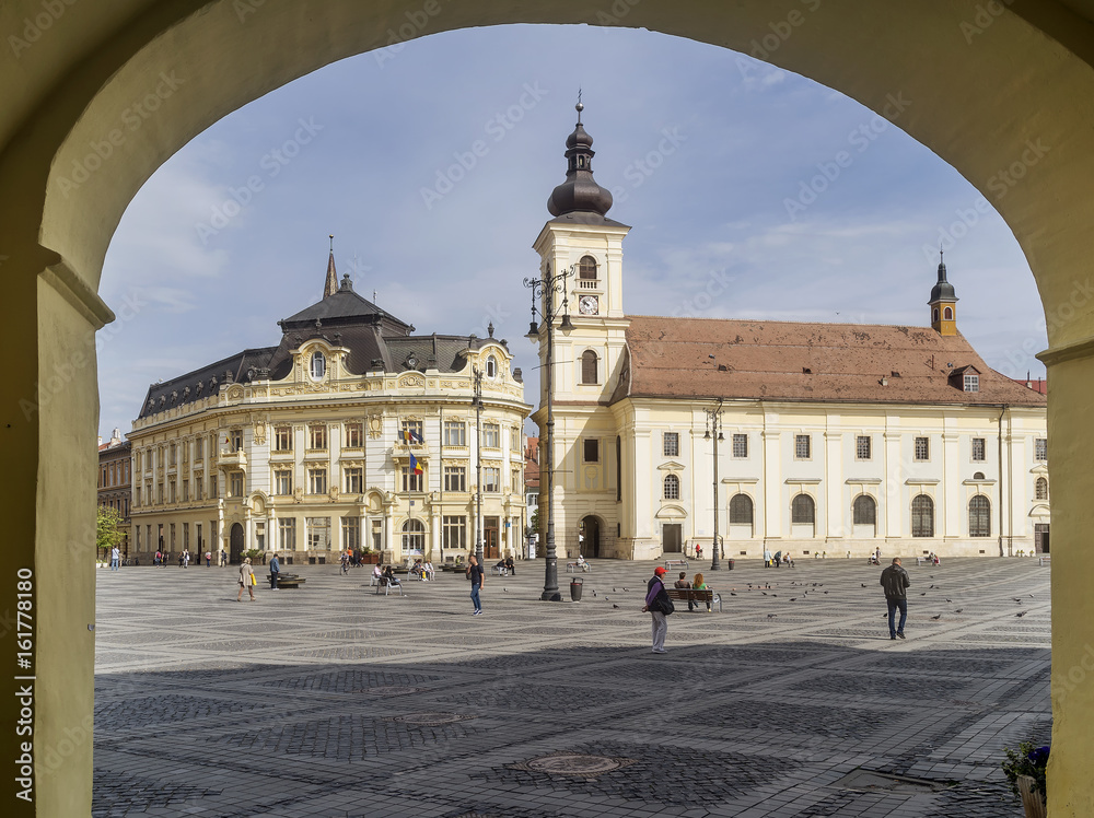 The famous Piata Mare, Large Square, Sibiu, Romania, framed by an arch, with the Holy Trinity church in the background