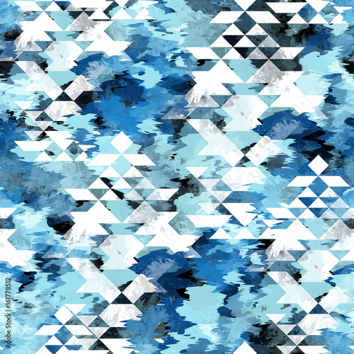 Seamless pattern tie-dye design with navajo triangles. Indigo background with watercolor effect. Textile shibori print for bed linen, jacket, package design, fabric and fashion concepts.