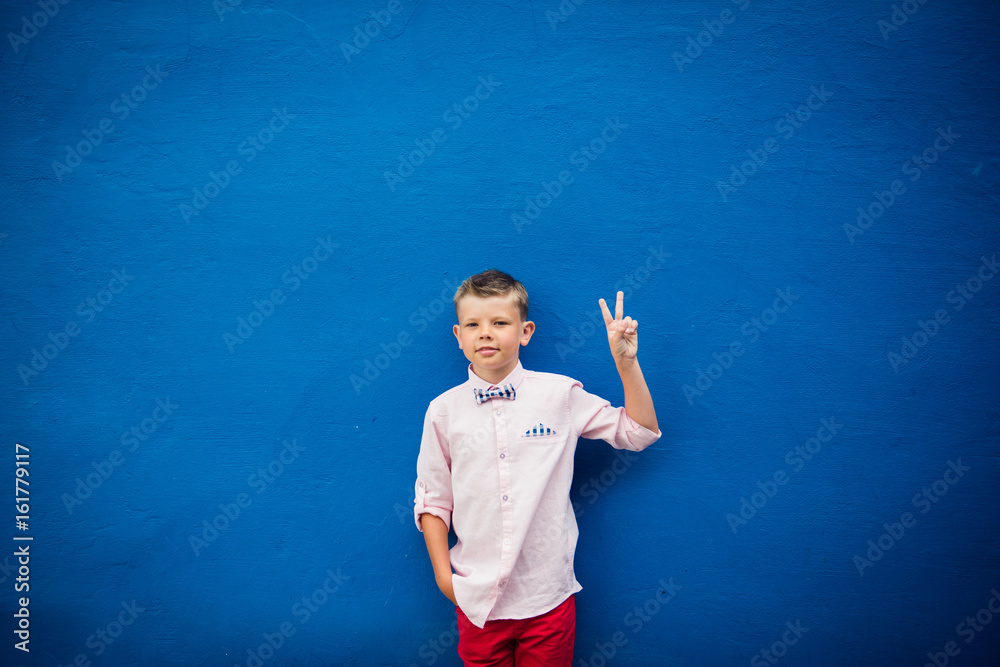 cute stylish boy making peace sign