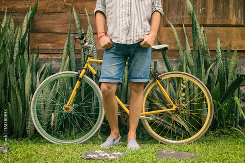 Young attractive man enjoying outdoors with old bicycle.