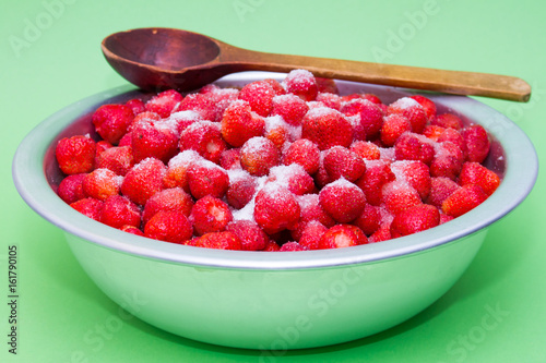 Strawberries in a manufacturer with sugar and jars for making jam. photo