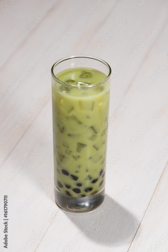 Boba / Bubble tea. Homemade Matcha Milk Tea with Pearls on wooden table.