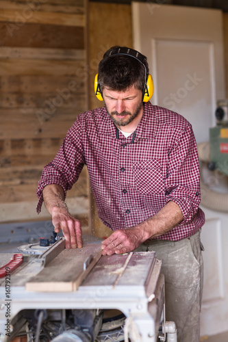 Male Carpenter cutting plank by circular saw © guerrieroale