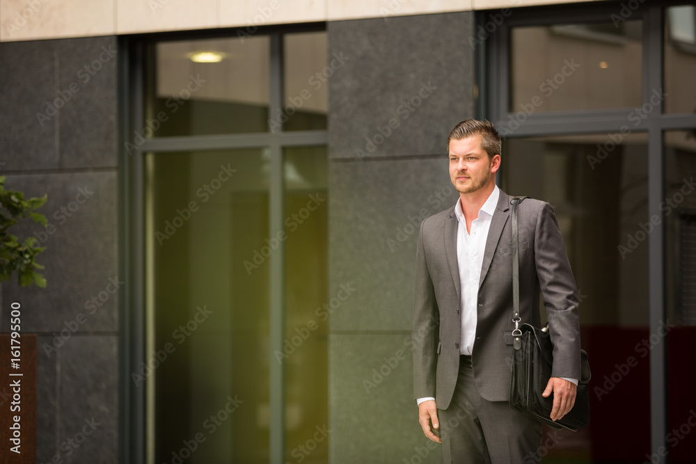 Business Mann / Herr verlässt Arbeitsgebäude / Feierabend / Termin Business Mann / Herr verlässt Arbeitsgebäude / Feierabend / Termin