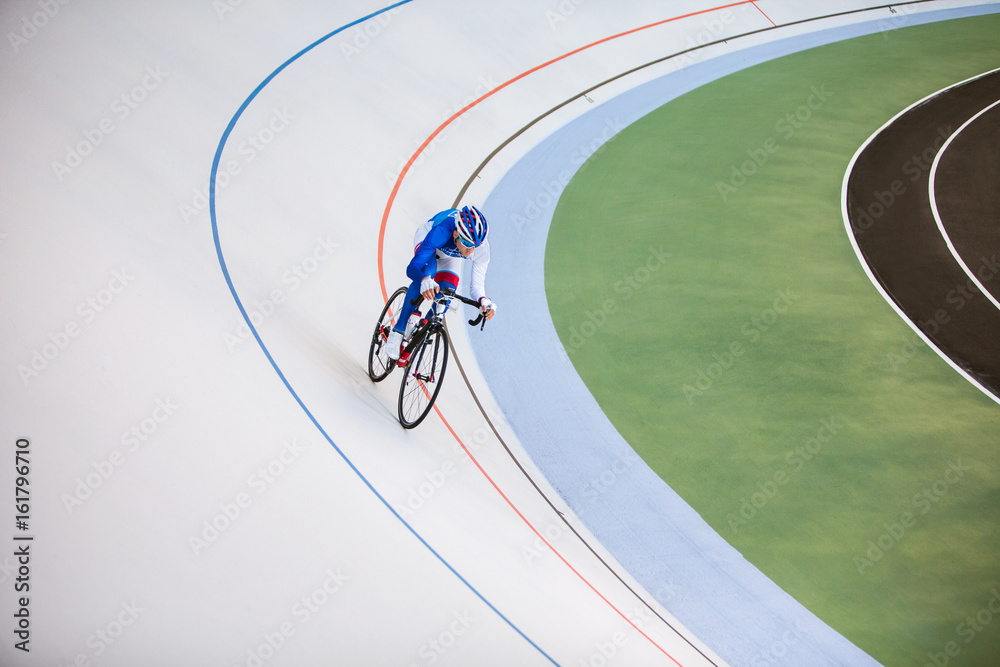 Racing cyclist on velodrome outdoor.