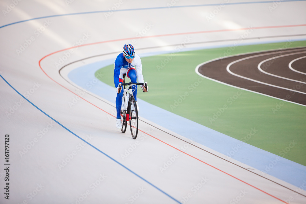 Racing cyclist on velodrome outdoor.
