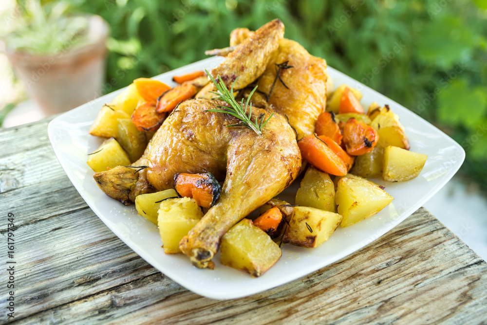 Piatto di pollo arrosto con contorno di patate e carote al forno Piatto di pollo arrosto con contorno di patate e carote al forno