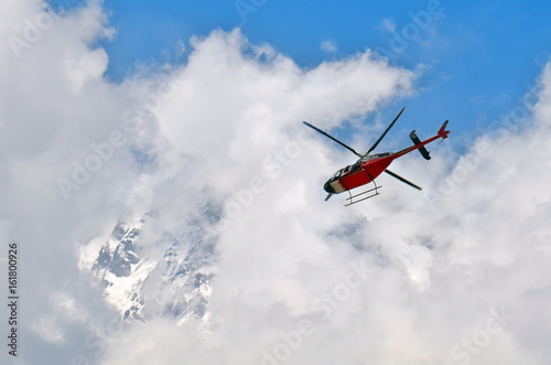 Helicopter in the cloudy sky and mountain. Himalayan Mountains, Annapurna National Park.