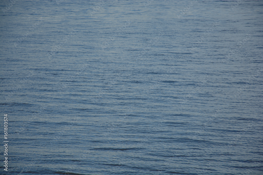 Water surface with ripples and sunrays reflections Water surface with ripples and sunrays reflections