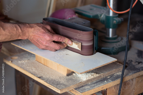 Carpenter's Hand using electric sander tool photo