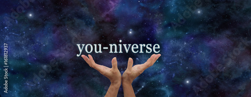 YOU are EVERYTHING - Hands reaching up with the word YOU-NIVERSE floating above against dark blue night sky background with plenty of copy space photo