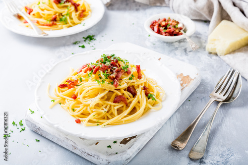 Tableau sur toile Italian pasta spaghetti Carbonara with fried bacon, parmesan cheese and parsley on white plate