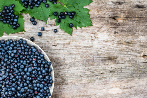 Fresh blueberries in basket on old table, ripe fruits from forest on farmer market, copy space, overhead