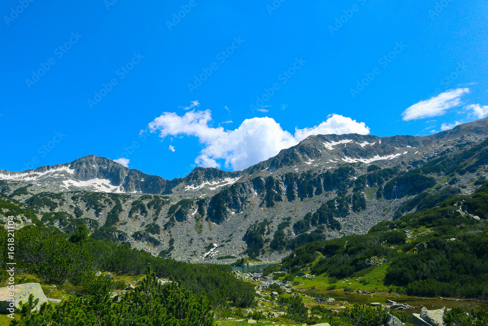 Beautiful view on the high green mountains peaks, on the blue sky background. Mountain hiking paradise landscape, no people.