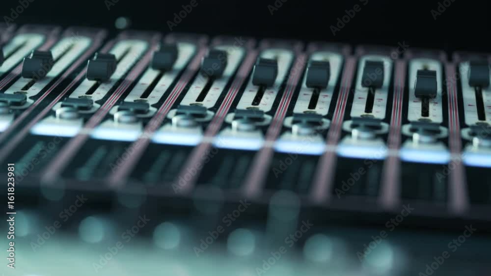 Soundboard knobs. ecording studios audio console and buttons. DJ Workplace. Music Mixer desk table in recording studio. shallow depth of field. Professional audio engineer working on audio mixer knobs Soundboard knobs. ecording studios audio console and buttons. DJ Workplace. Music Mixer desk table in recording studio. shallow depth of field. Professional audio engineer working on audio mixer knobs