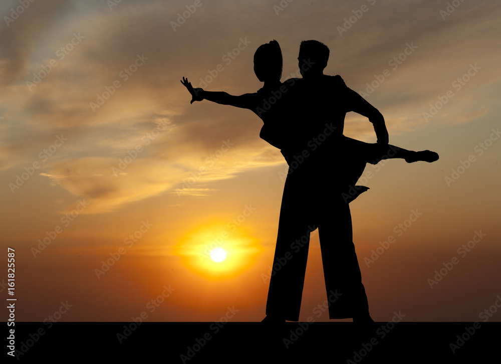 Silhouette couple in the active ballroom dance on sunset