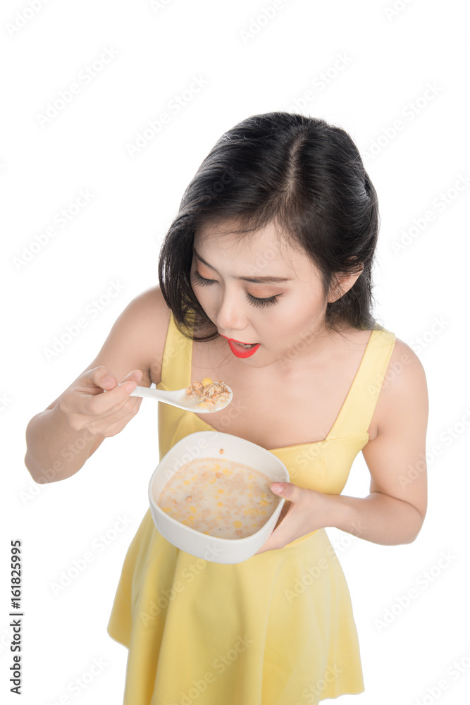Asian woman eating bowl of cereal or muesli for breakfast Asian woman eating bowl of cereal or muesli for breakfast