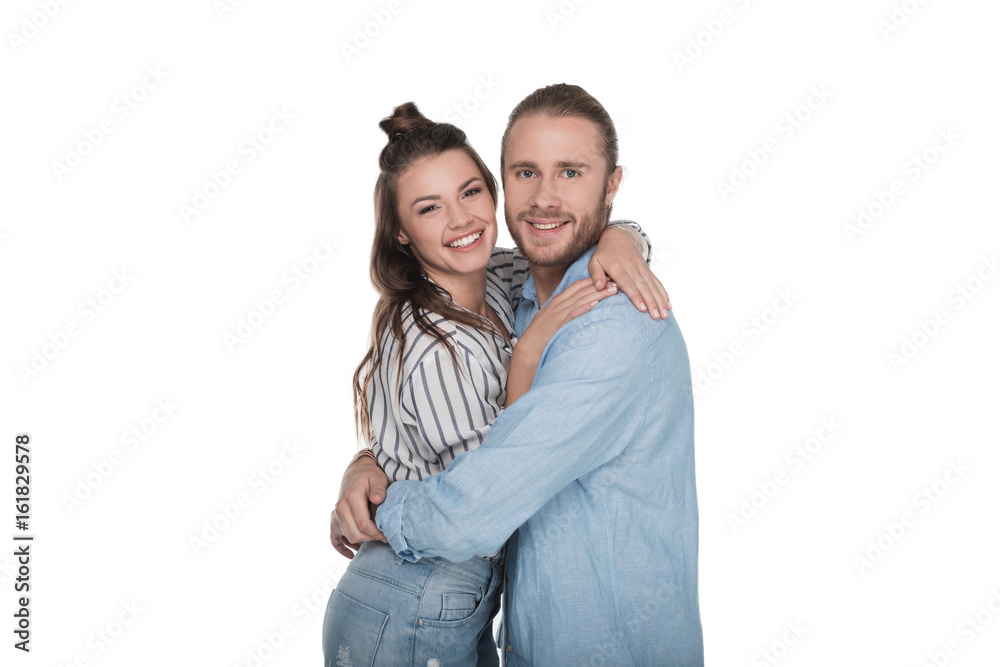 Happy young couple standing embracing and smiling at camera isolated on white Happy young couple standing embracing and smiling at camera isolated on white