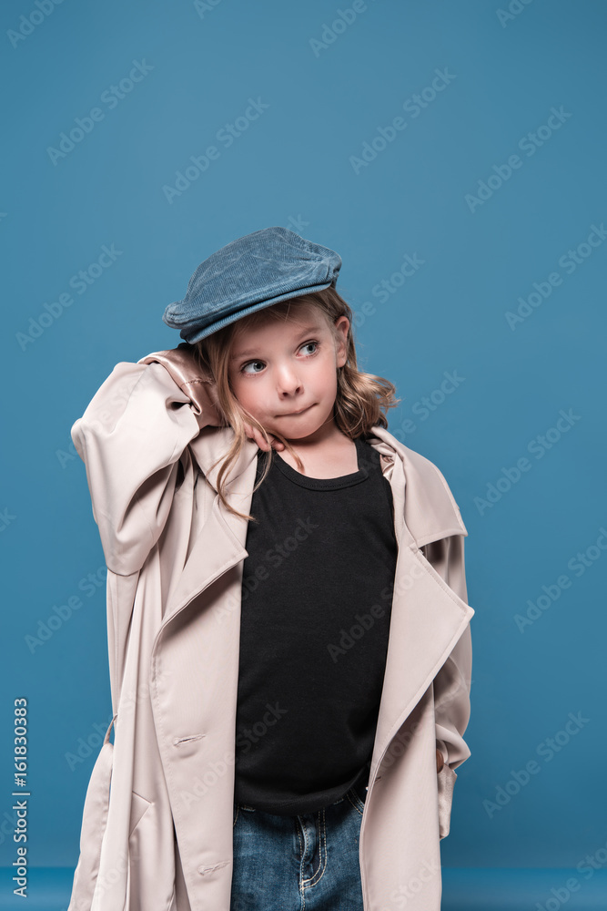 Cute little girl in cap looking away isolated on blue Cute little girl in cap looking away isolated on blue