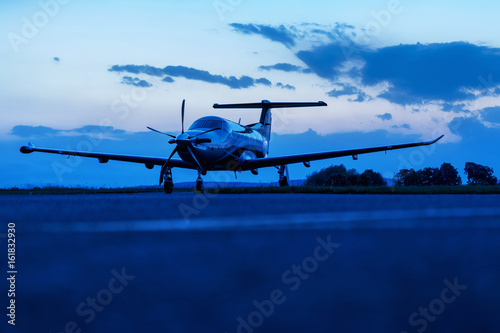 Single turboprop aircraft on evening runway.