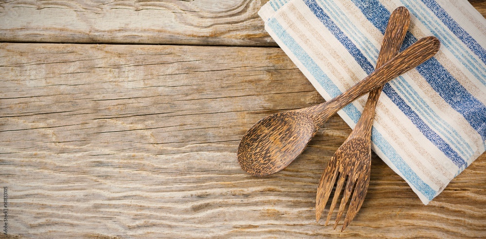 Wooden spoon and fork with napkin on table Wooden spoon and fork with napkin on table