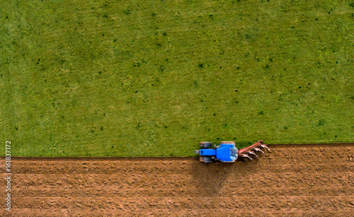 Fotografia Tractor Ploughing Plowing Field - Aerial Shot