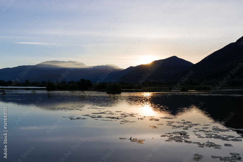Beautiful foggy sunrise sunset silhouette reflection at Iseo lake in Italy in summer