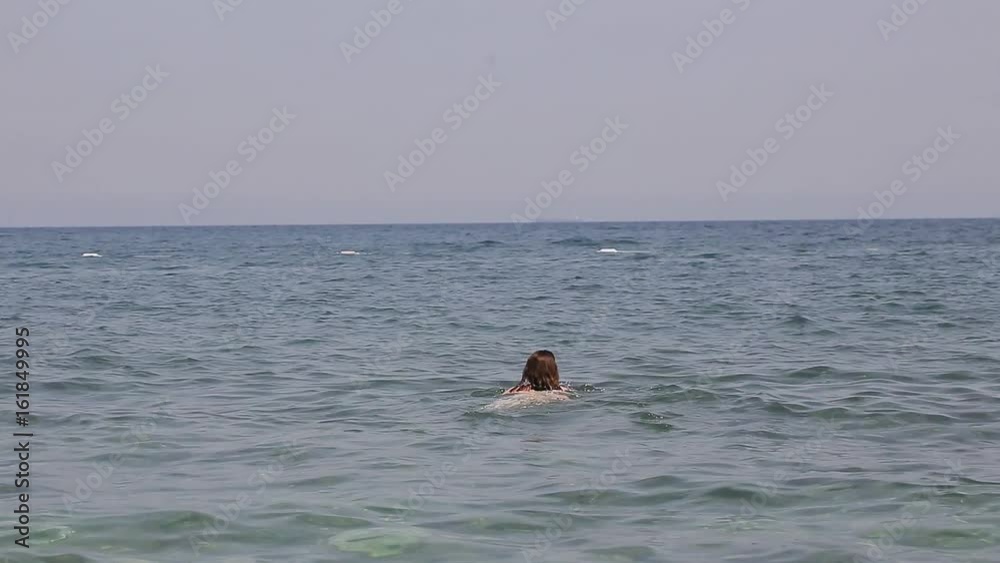The girl is swimming in the sea The girl is swimming in the sea