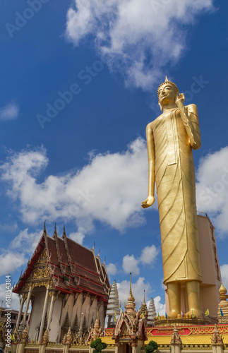 The public Buddha imagae statue tallest standing at wat Burapapiram temple Roiet, thailand blue sky background photo