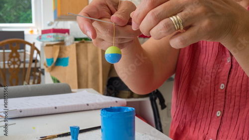 female hands painting polymer clay. Handmade workshop composition of clay, beads, tools and paint in studio