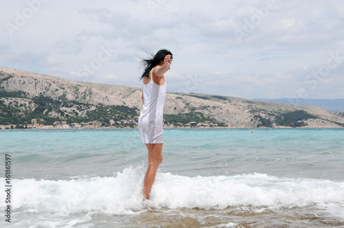 frau im kleid und bikini am meer badend photo