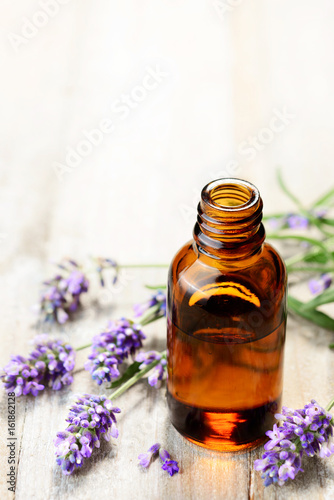 Lavender essential oil in the amber bottle, on the wooden table