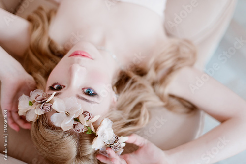 picture of young blonde woman wearing wreath of flowers, spring tender and romantic portrait, fashion retouched shot