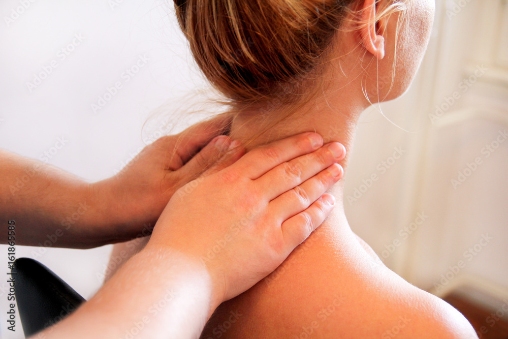 Massage relax studio. Woman having her neck massaged by a physiotherapist.  Massage therapist massaging neck muscles. Body care. Beautiful young girl  relaxing with hand massage at beauty body spa. Stock Photo