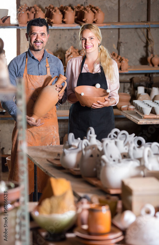 Wallpaper Mural man and woman potters holding ceramic vessels in atelier Torontodigital.ca