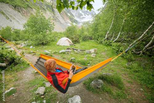 Traveler relaxing in hammock, a camp with magic view