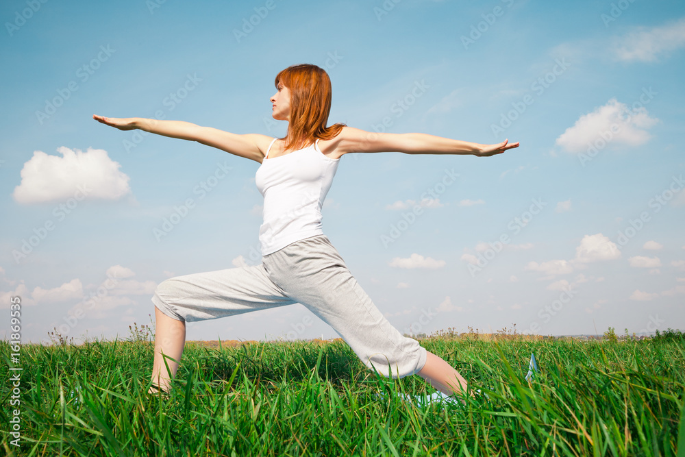 Young girl doing yoga in the park over blue sky Young girl doing yoga in the park over blue sky